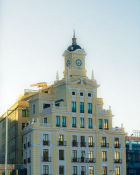 Elegant historic clock tower building in Madrid, Spain, captured under bright daylight.