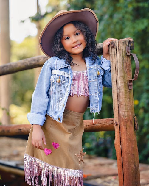 A little girl in a cowboy hat and skirt