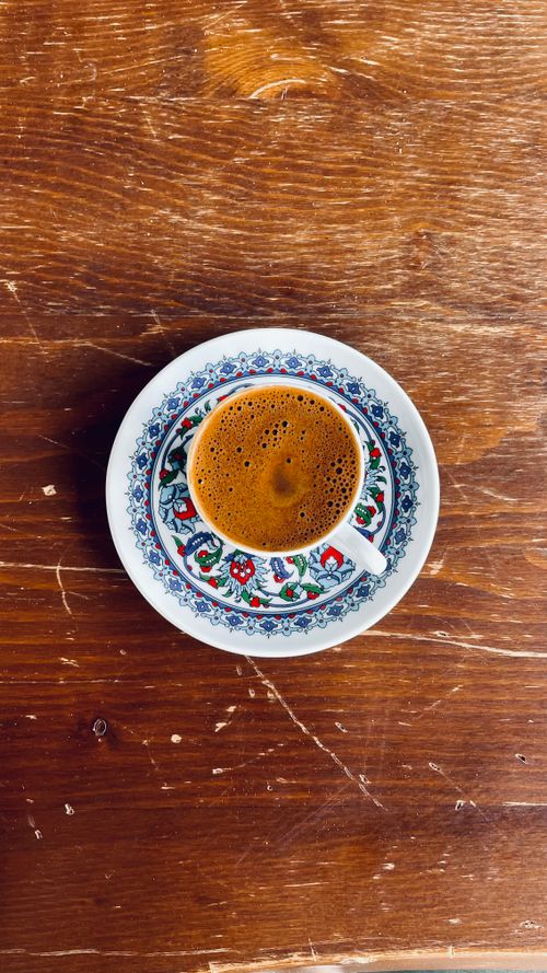 Free Stylish coffee cup with intricate patterns on a wooden table, offering a warm vibe. Stock Photo
