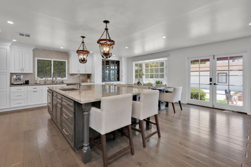 Free Luxurious modern kitchen with island, chandelier lighting, and elegant furnishings. Stock Photo