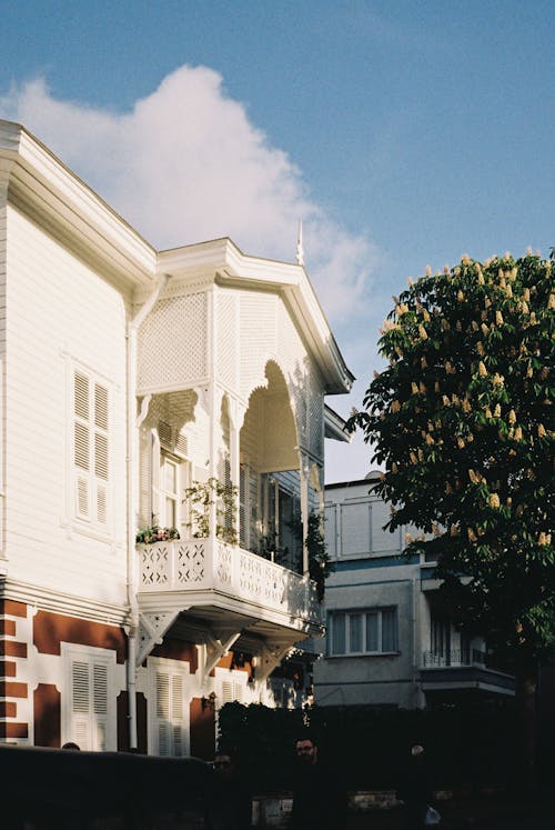 Free A white house with a balcony and a white car Stock Photo