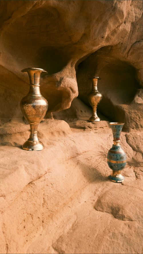 Free Three ornate brass vases in a rustic sandstone cave setting, evoking history and mystery. Stock Photo