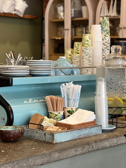 A counter with a coffee machine and cups and plates