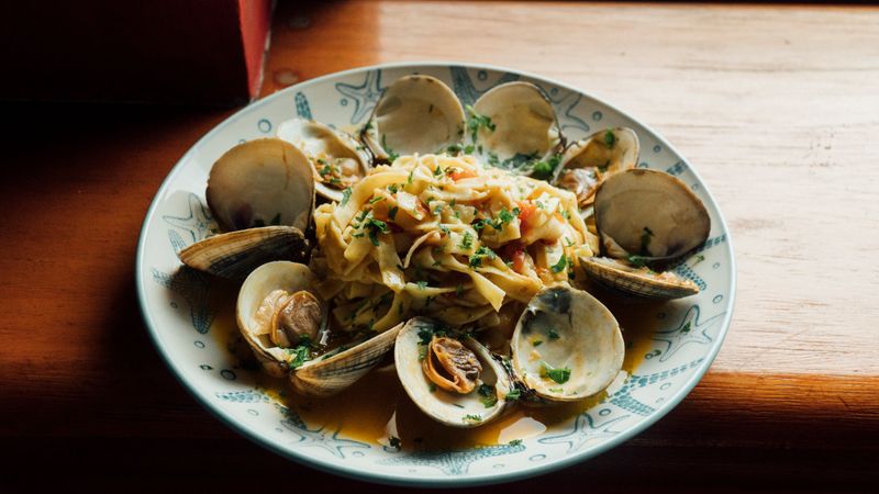 Pasta con anchoas, ajo y aceite de oliva servida con perejil fresco