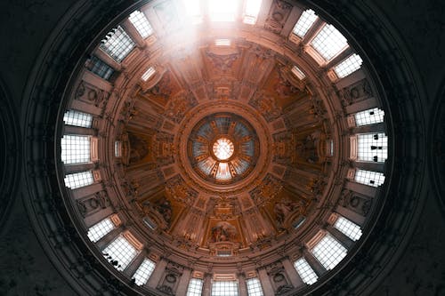 The dome of a church with a sun shining through it