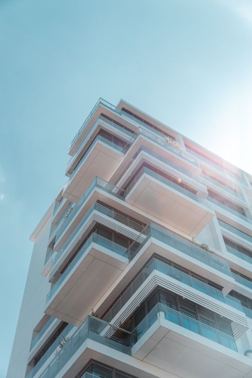 Free A stunning view of a modern residential building in Berlin with geometric balconies against a clear blue sky. Stock Photo