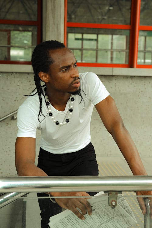 A man with dreadlocks leaning on a railing