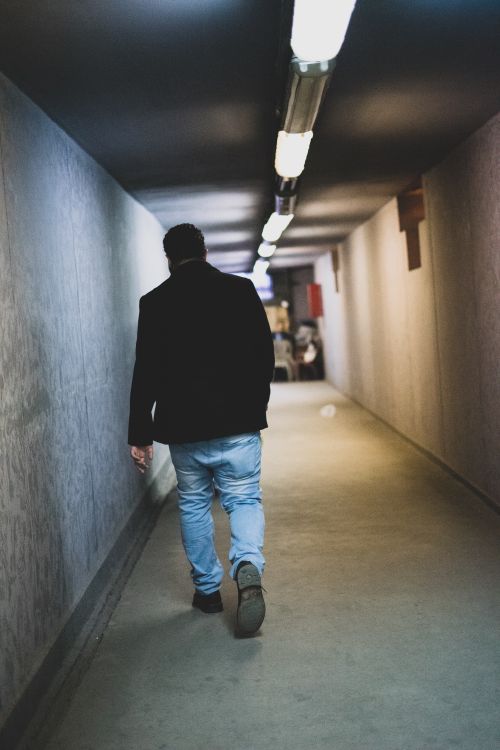 Free A solitary man walks through a well-lit underground passageway in Cairo, Egypt. Stock Photo