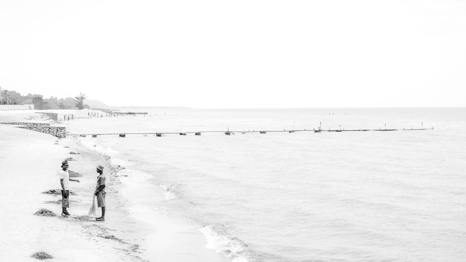 People collecting fishing nets on beach, Malawi