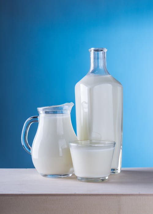 免费 牛奶在蓝色背景下的特写镜头 素材图片