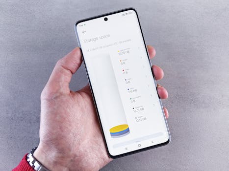 Hand holding smartphone displaying storage space usage with a clean interface.