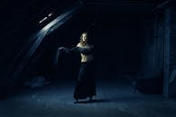 穆迪拍摄的女人站在黑暗怪异的阁楼空间里