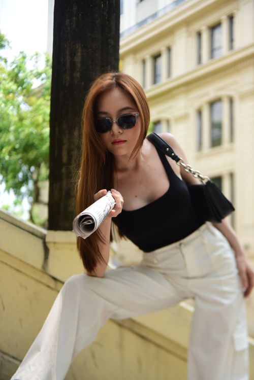 Free Stylish Asian woman in sunglasses posing with newspaper outdoors, summer fashion shoot. Stock Photo