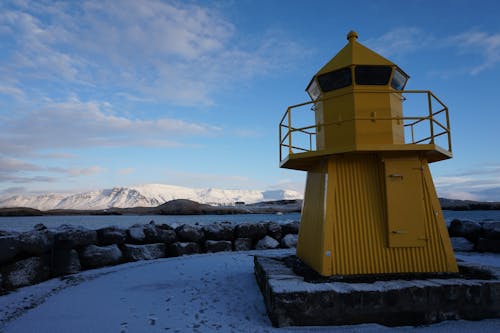 Phare Jaune Et Gris Devant Les Montagnes