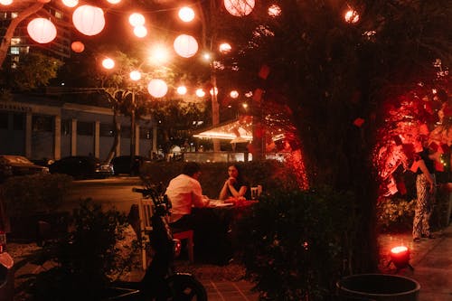 A restaurant with red lights and lanterns hanging from the ceiling