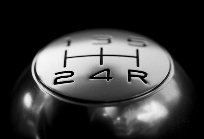 Close-up of a manual gear stick inside a car.