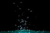 在黑暗背景下，充满活力的水花和气泡升起的特写