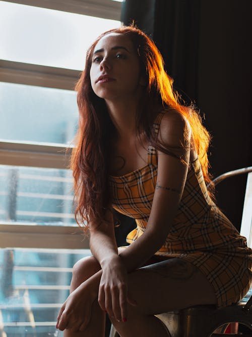 Free Photo of Woman in Yellow Dress Sitting by Window Looking Woman Stock Photo