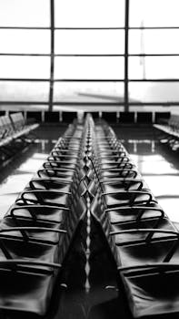 Rows of empty seats in Dubai airport terminal, highlighting modern architecture.