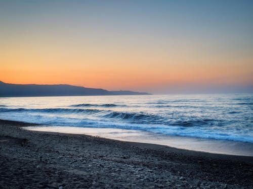 бесплатная Волны плещутся на берегу пляжа с черным песком Стоковое фото
