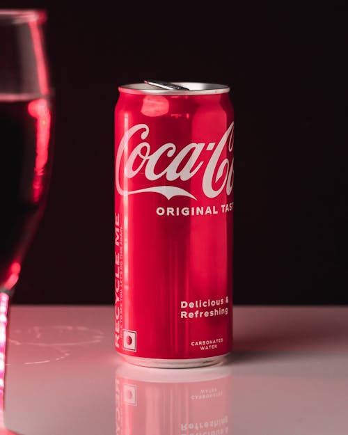 A can of coca cola next to a glass of wine