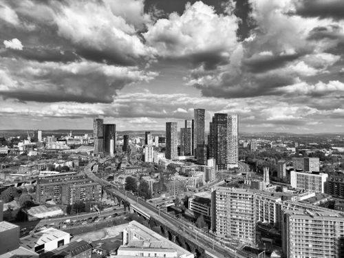 Free Explore the dynamic Manchester cityscape in this dramatic black and white aerial shot. Stock Photo