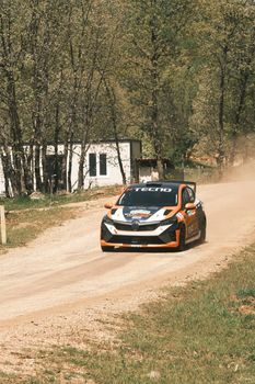 Rally car speeding on dirt road in Bursa, Türkiye, leaving a trail of dust.