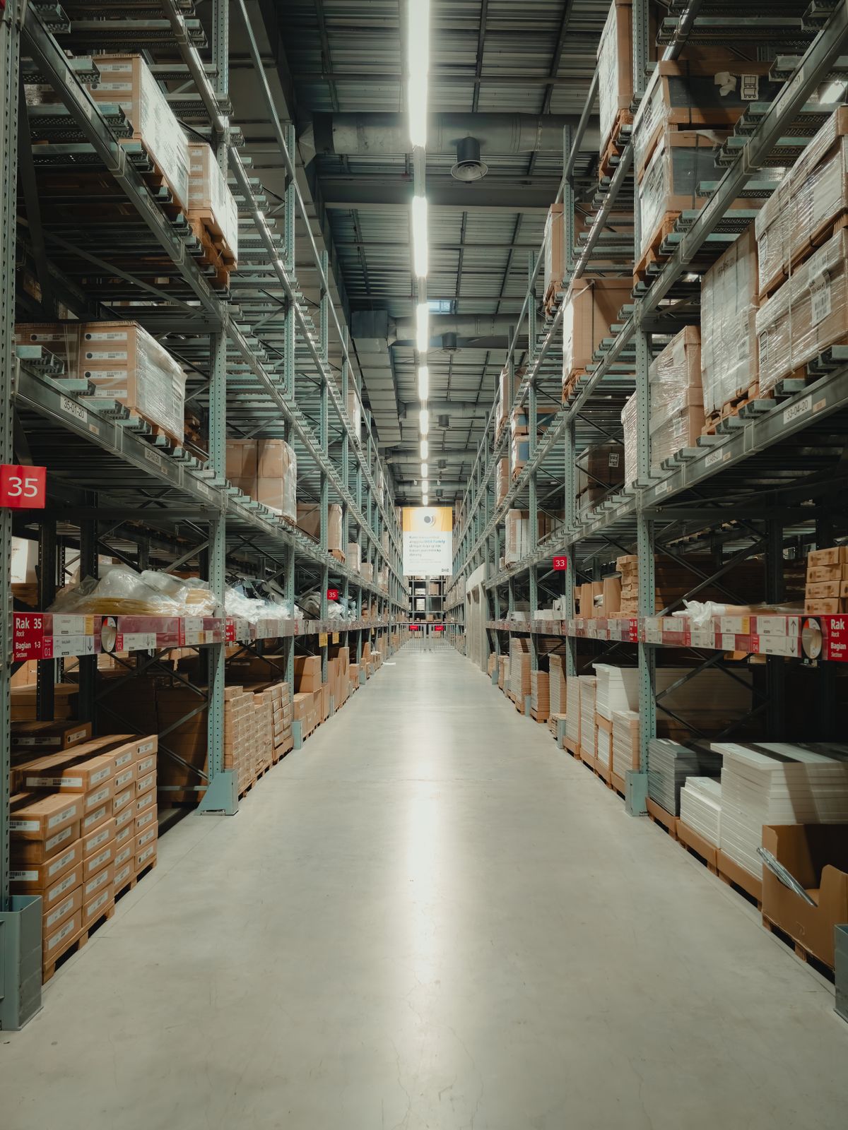 Spacious warehouse aisle stocked with retail products on shelving