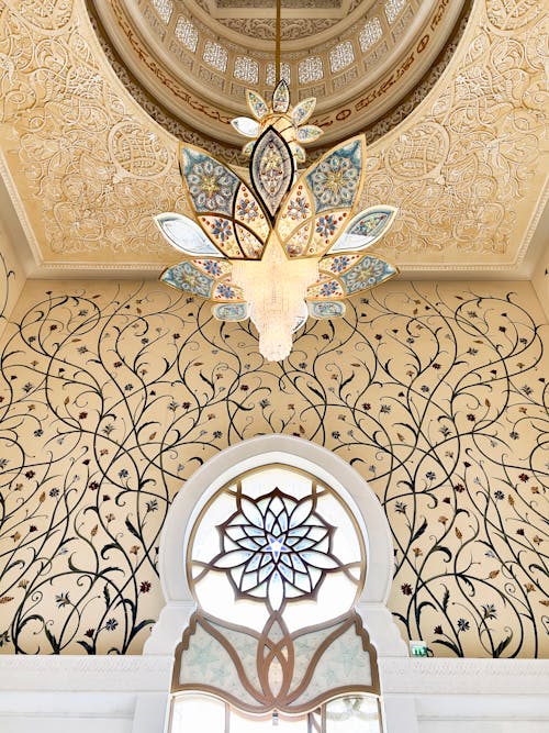 A ceiling with intricate designs and a chandelier