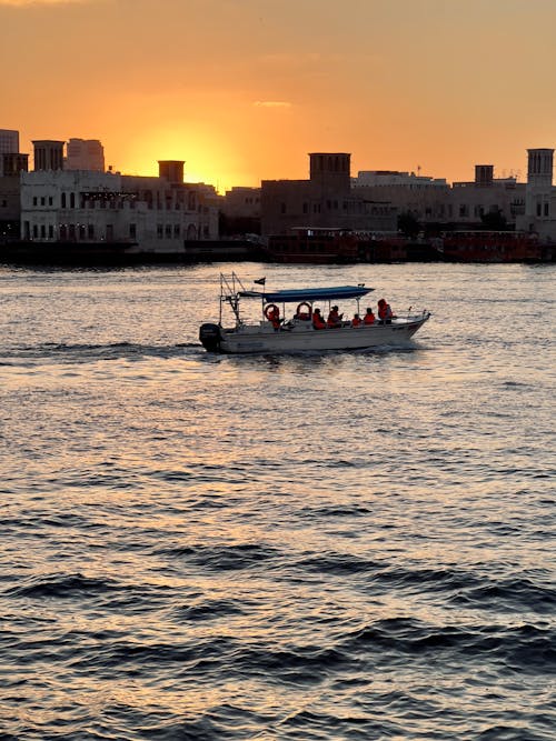 A boat is traveling on the water at sunset