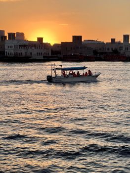 Serene sunset view in Dubai featuring a boat on the water.