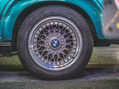 Detailed close-up of a vintage car wheel showcasing intricate rim design.