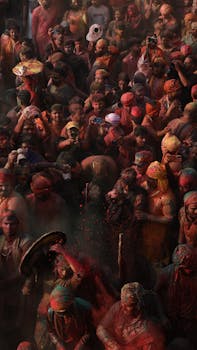An exuberant crowd celebrating Holi with colorful powders in India, showcasing vibrant cultural traditions.