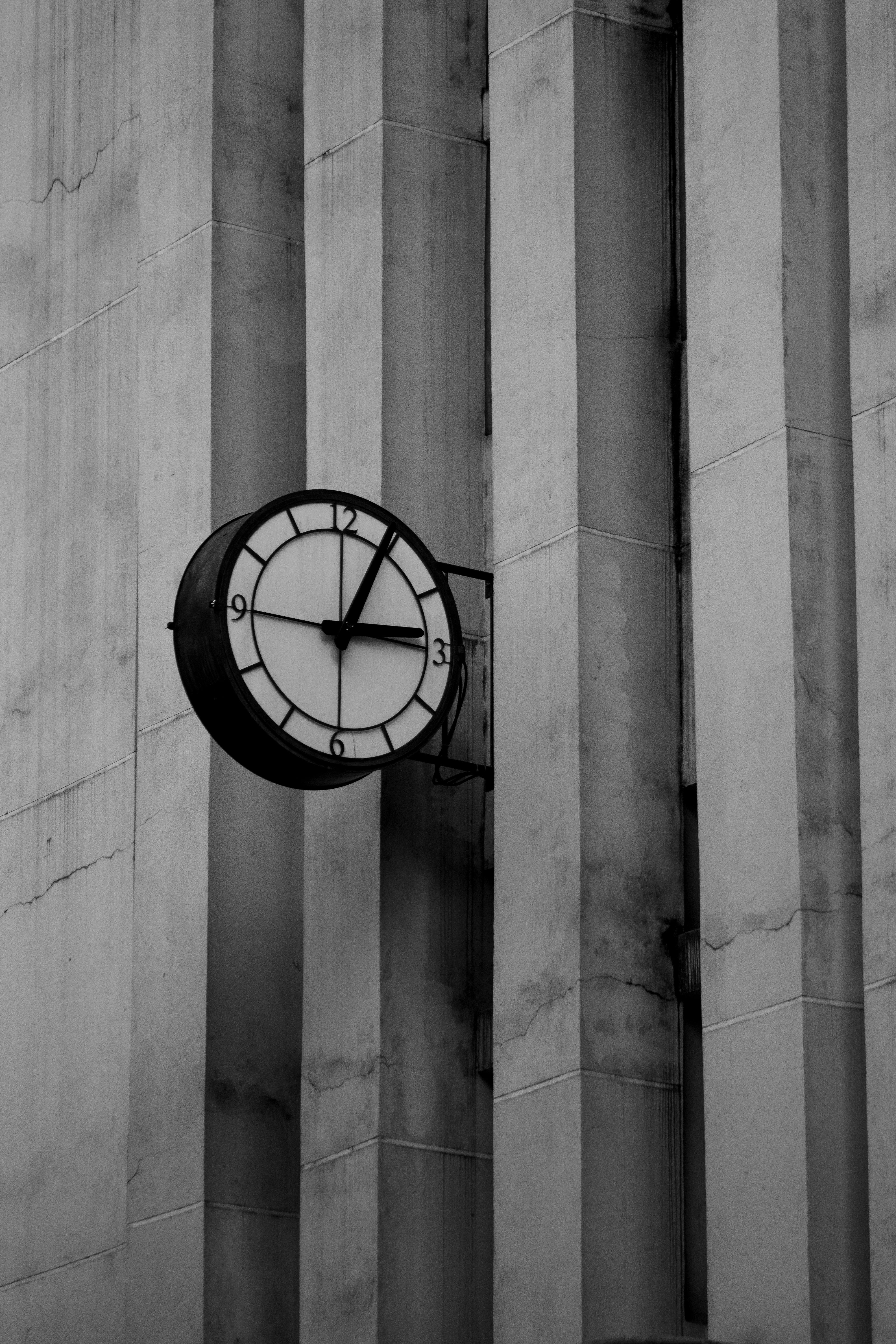 Monochrome image of a vintage clock on a building facade in Curitiba, Brazil.