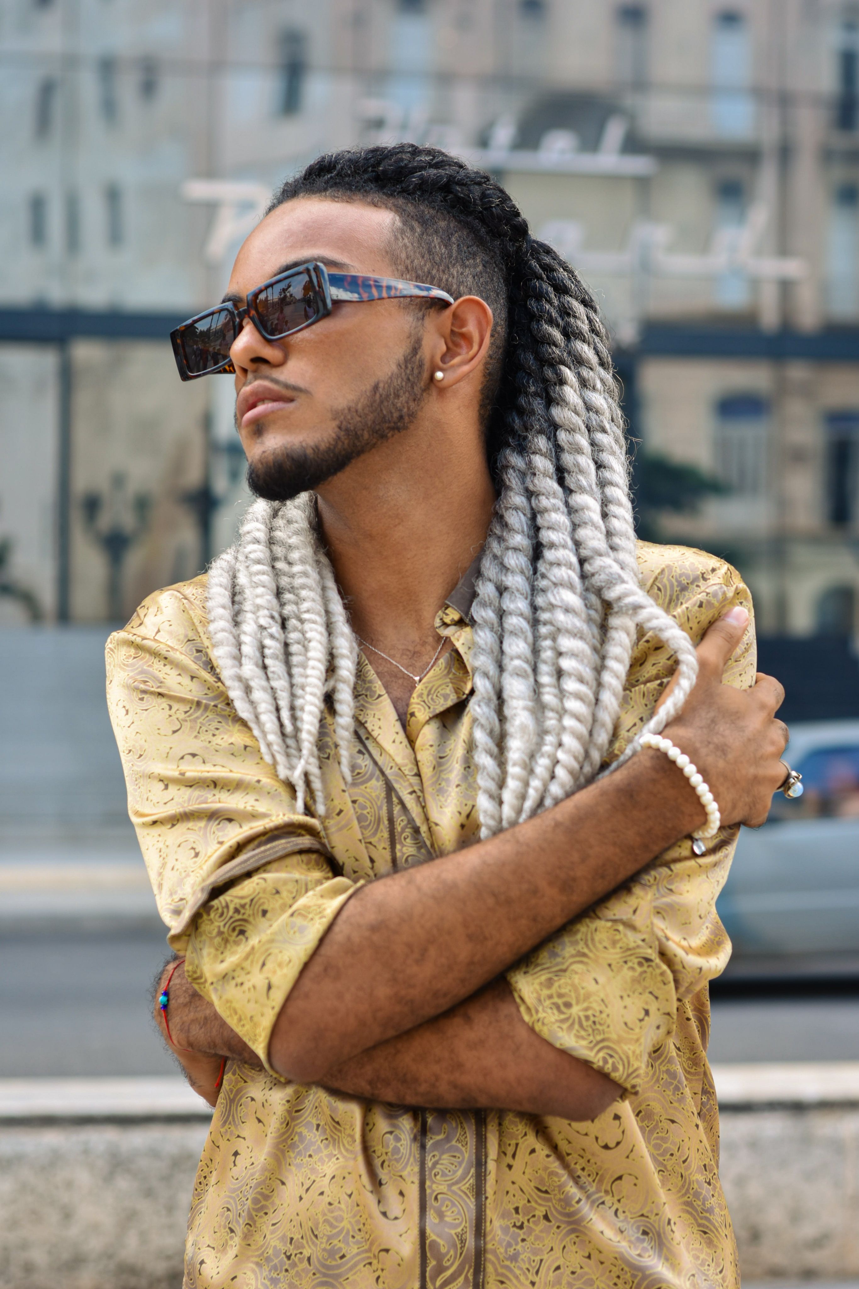 A fashionable man with braided hair and sunglasses in the streets of Havana, Cuba.
