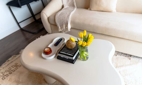 A white coffee table with flowers on it