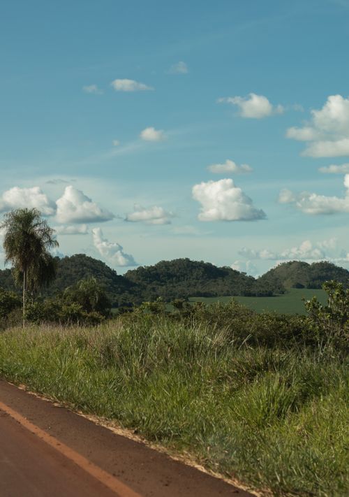 Free Enjoy a scenic view of Bonito's lush terrain with clouds dotting the sky and a tranquil road. Stock Photo