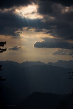 Captivating mountain silhouette with dramatic clouds and golden sunset light.