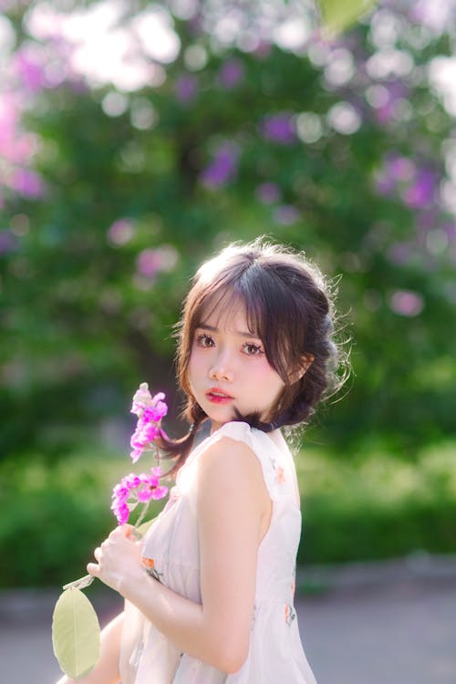 A girl with long hair holding a flower