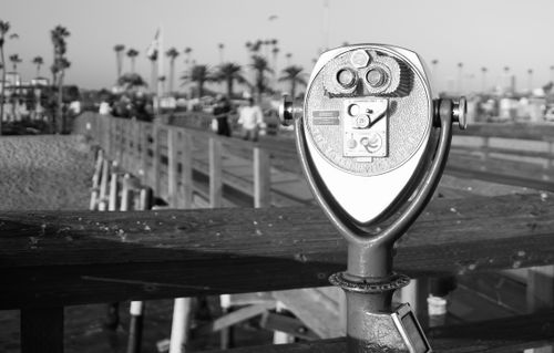 Free Monochrome viewfinder on a wooden pier overlooking a busy beach scene. Stock Photo