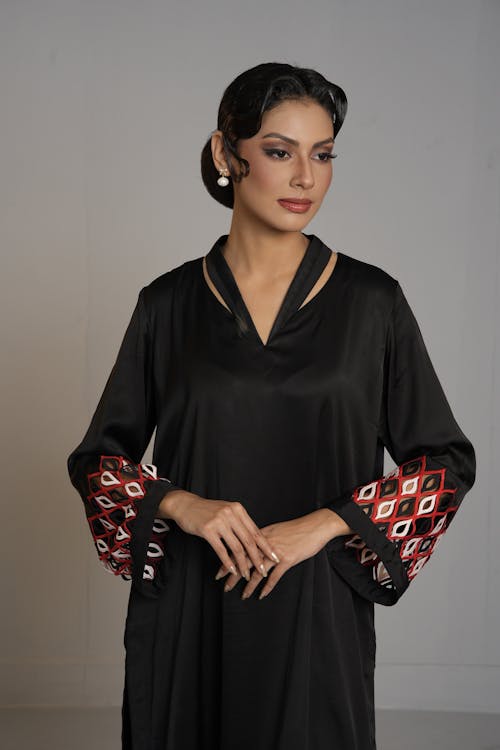 A woman in black and red dress with embroidered sleeves