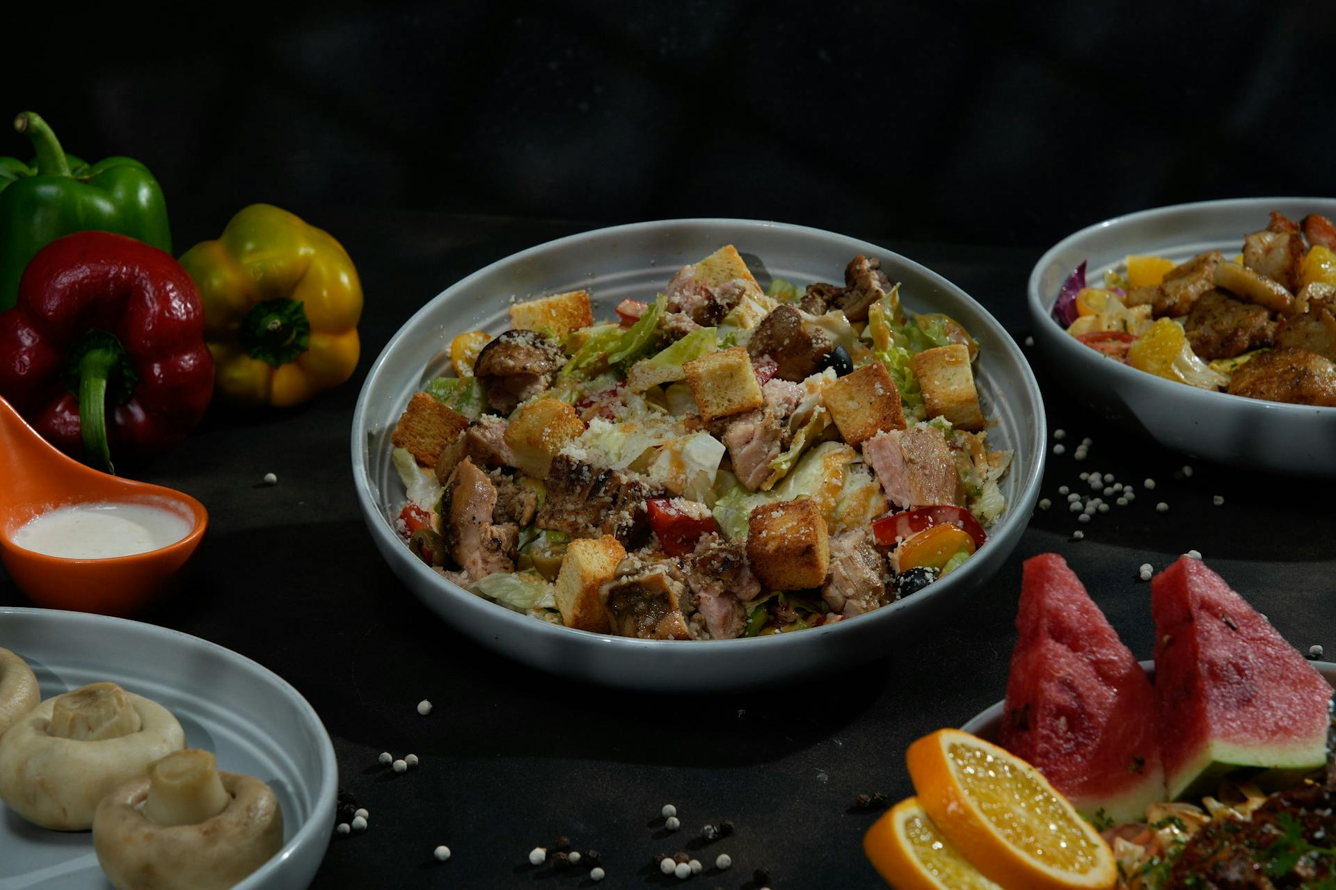 Bowl of Caesar Salad with Croutons and Pork Among Other Dishes