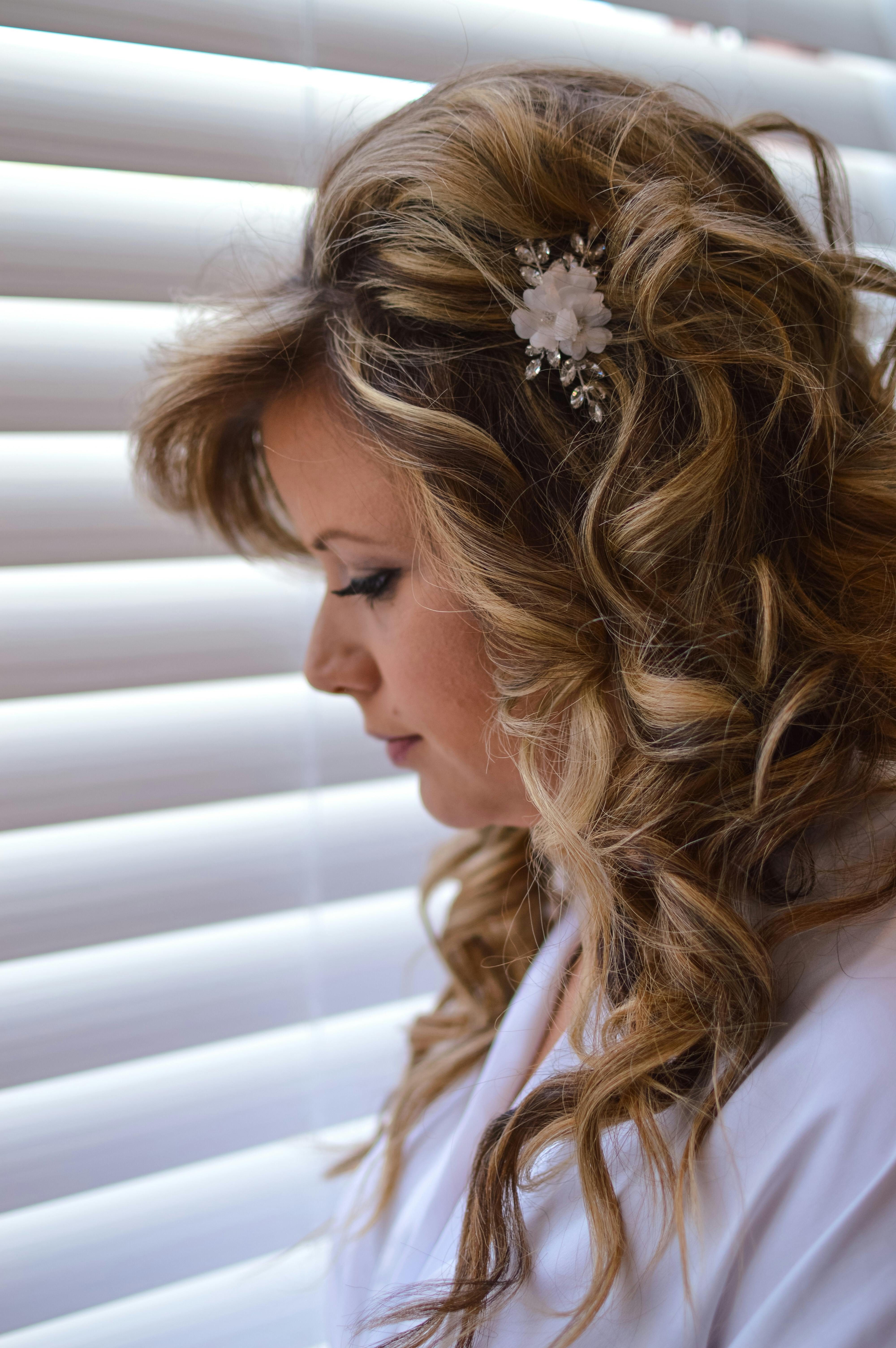 Close-up Side View Photo of Woman in White Top Standing Beside Window With Venetian Blinds