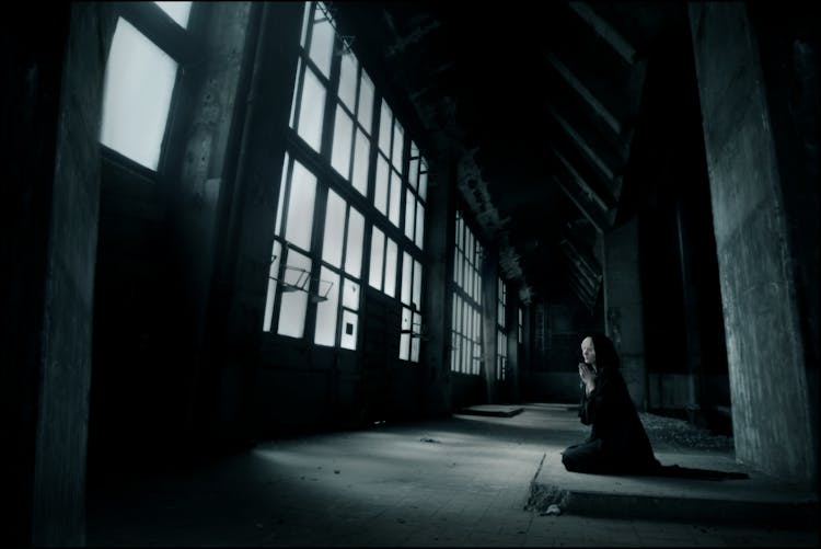 Woman Praying Inside Building