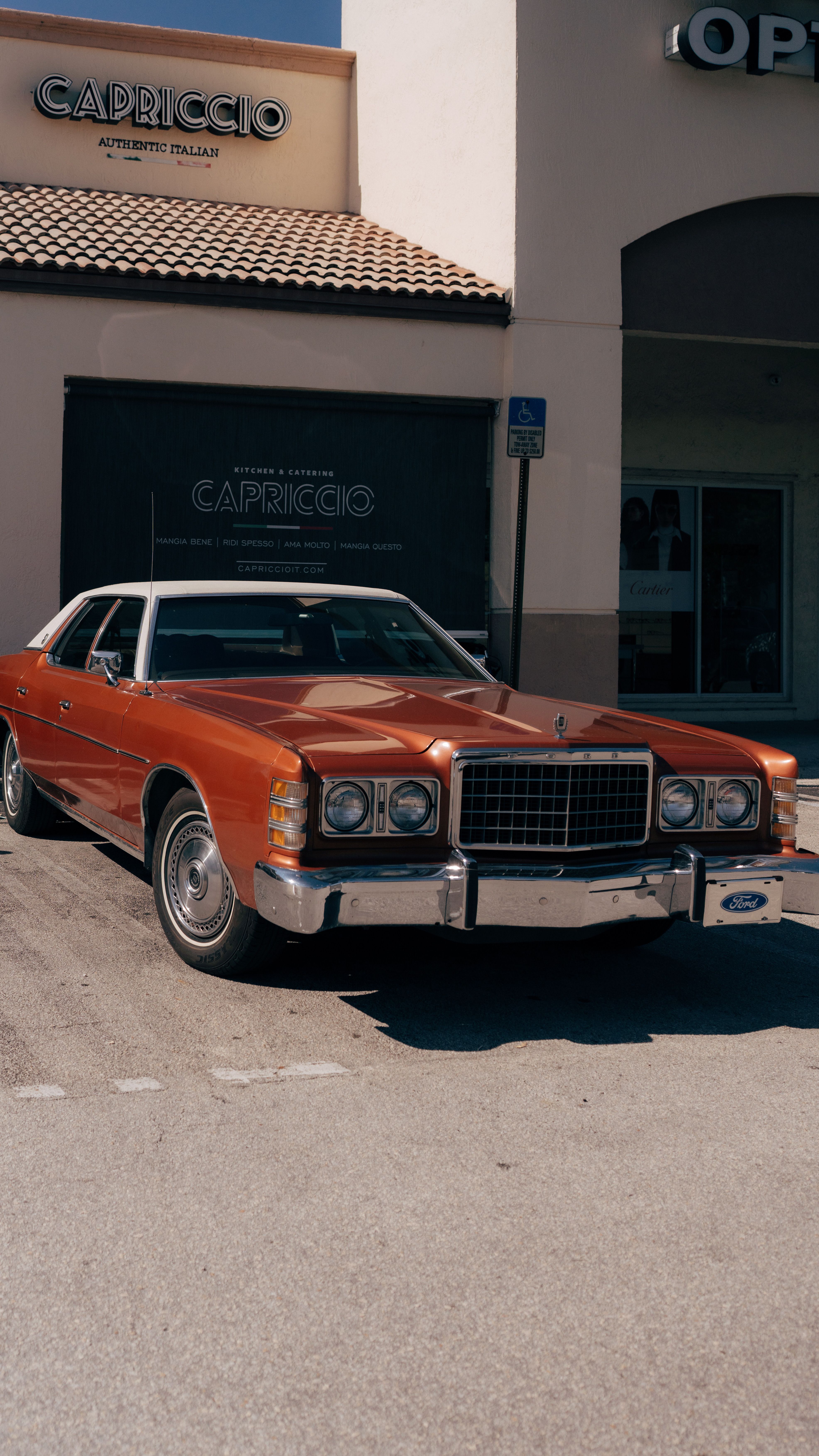 Classic Ford LTD parked outside a city building, showcasing vintage car design.