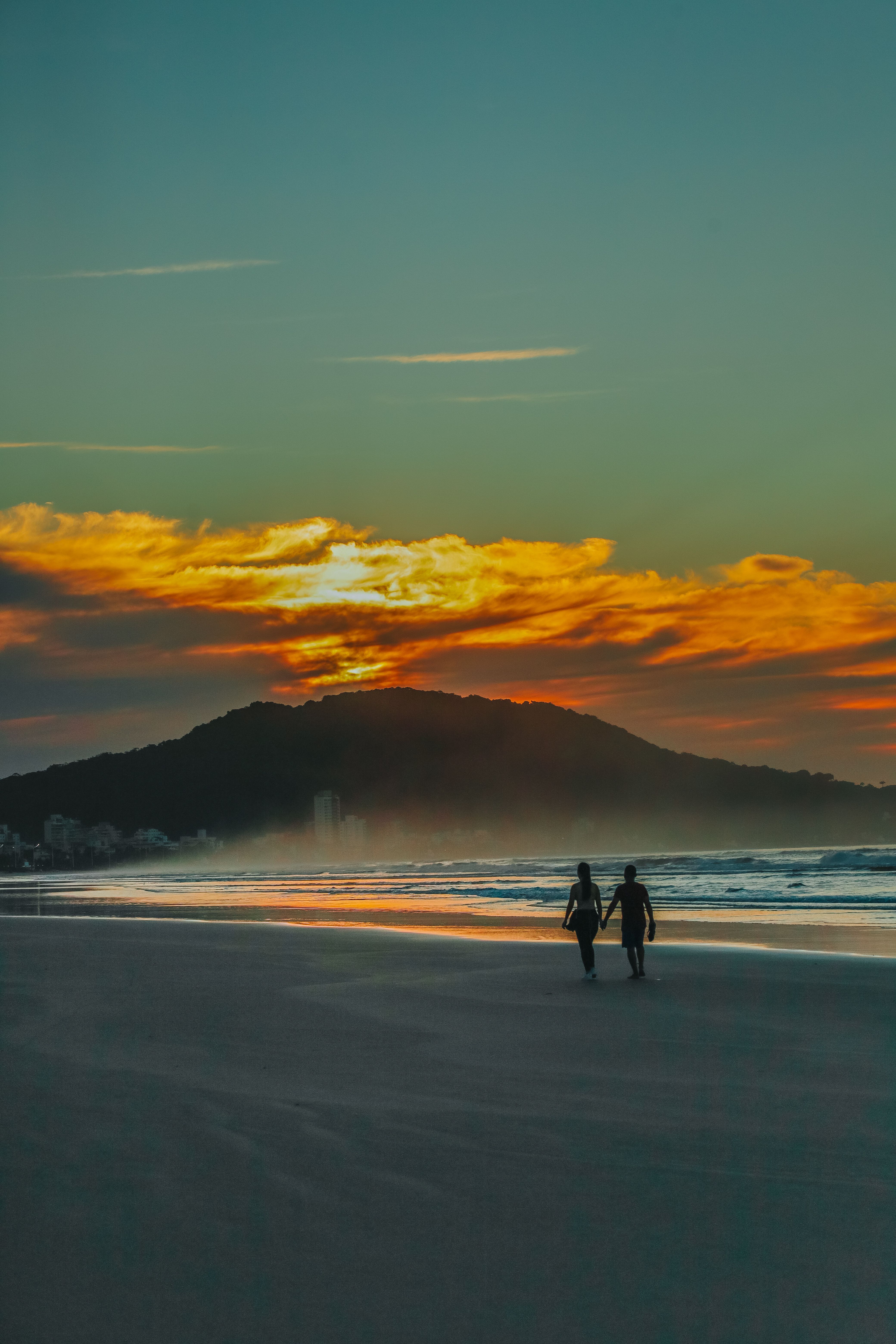 Silhouette of Two People Walking on Beach during Sunset · Free Stock Photo