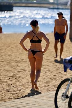 Beachgoers enjoying a sunny day by the sea, capturing a relaxing summer moment.