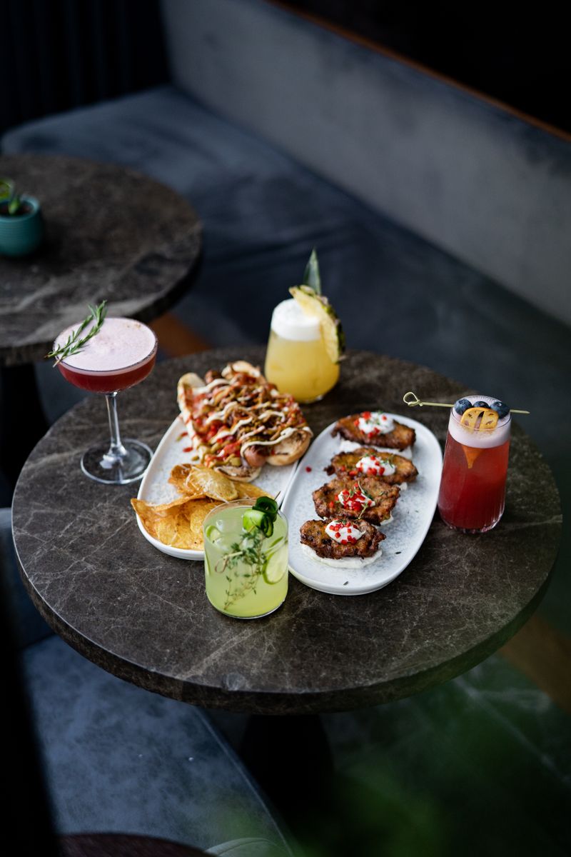 Bebidas, comida y carne en la mesa del gastrobar