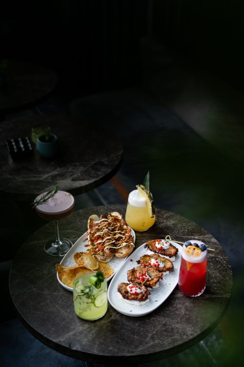 Free Stylish table setting featuring various cocktails and delicious appetizers on a dark marble surface. Stock Photo