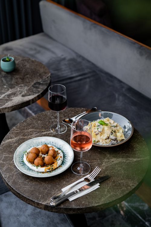 Free Cozy restaurant setting with wine and delicious pasta on a marble table. Stock Photo